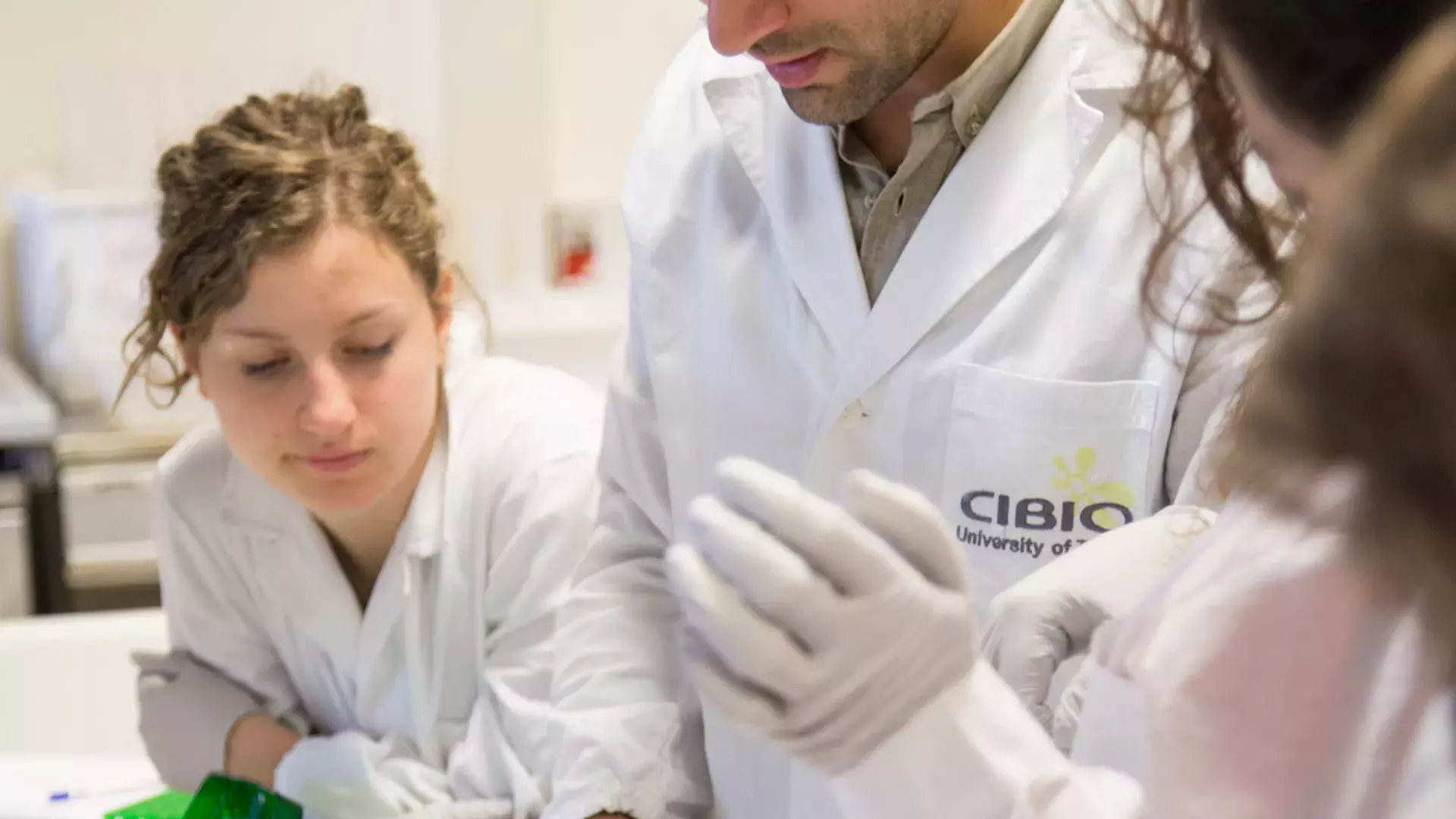 volto di giovane studentessa in laboratorio, guanti e camice